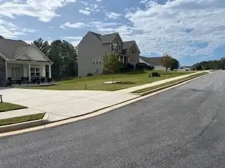 Neighborhood street in Covington, GA with well-kept front lawns and driveways maintained by Edwards Landscaping