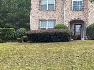 Front yard in Covington, GA with freshly mowed grass and trimmed shrubs maintained by Edwards Landscaping
