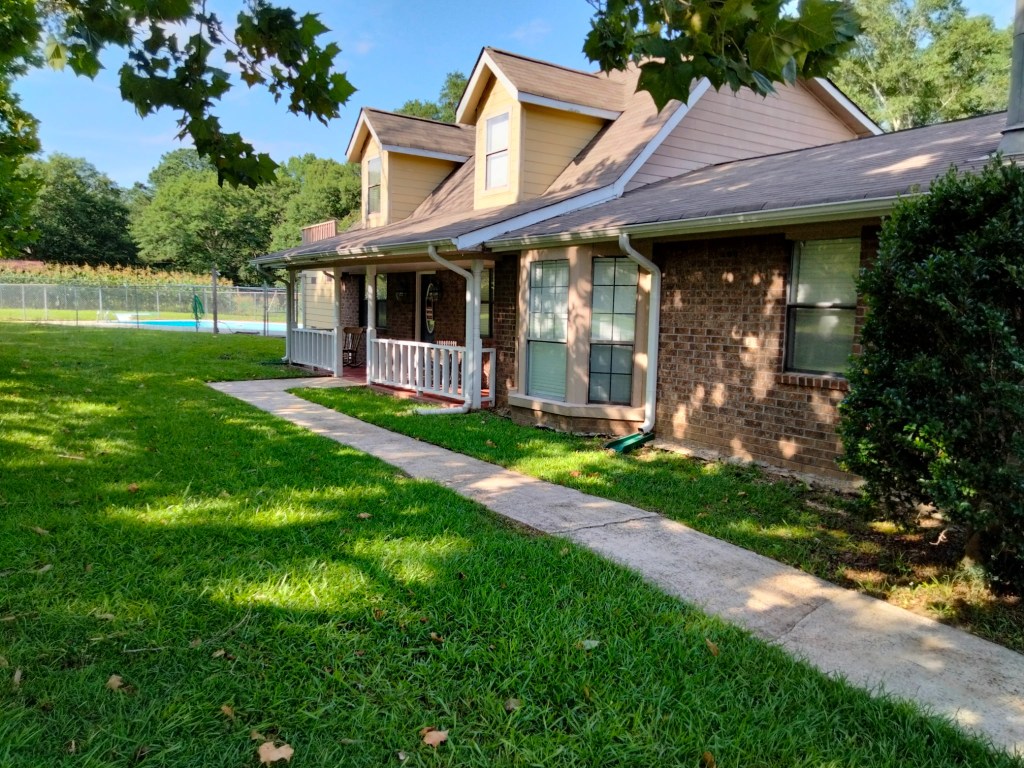 Thick, healthy green lawn with clean concrete walkway maintained by Edwards Landscaping lawn care service in Covington, GA