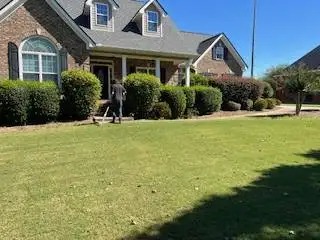 A happy customer walking into their residence after receiving our lawn mowing in Covington, GA service